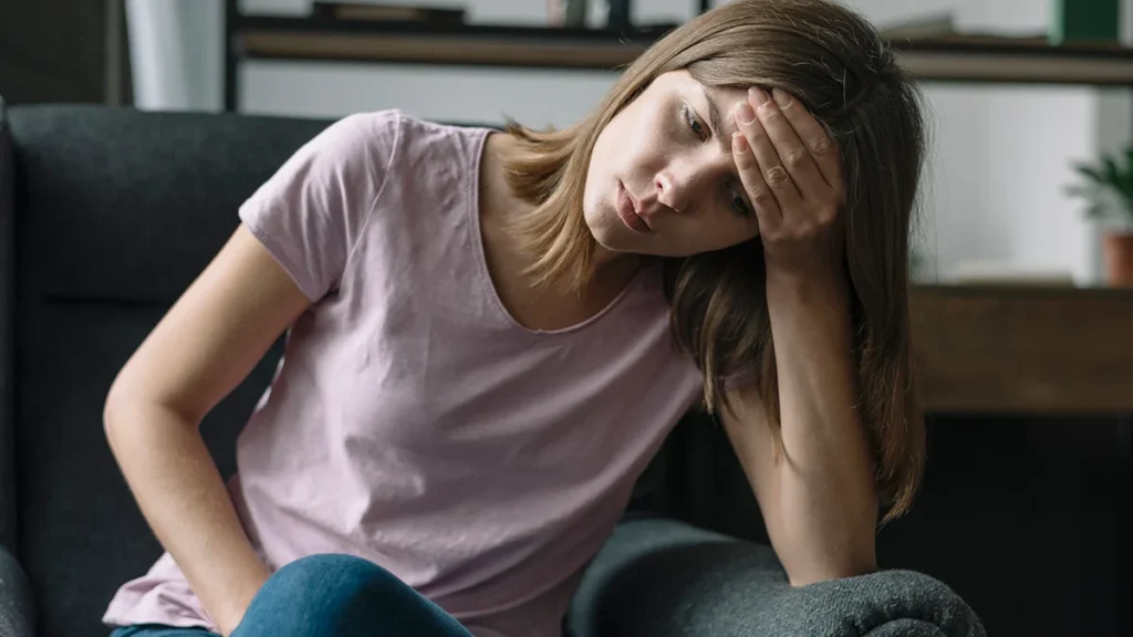 saddened woman with her hand on her forehead